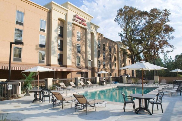 A hotel with a pool area, outdoor seating, and a sign reading "Hampton Inn & Suites". - Hampton Inn & Suites Mobile Providence Park/Airport (Mobile)
