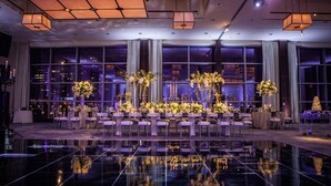 A spacious, well-lit event space with a reflective floor, large windows, and elegant floral centerpieces. - InterContinental Boston by IHG (Boston)