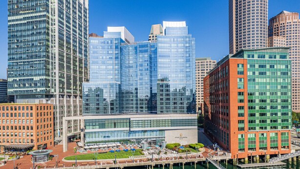 A modern building with a glass facade, a waterfront view, and a dock area with boats. - InterContinental Boston by IHG (Boston)