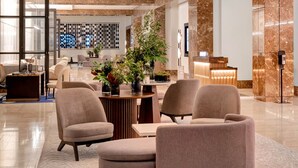 A modern lobby with a central seating area, a reception desk, and a distinctive geometric light fixture. - InterContinental Boston by IHG (Boston)