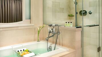 A bathroom with a bathtub, shower, and glass-enclosed shower area.