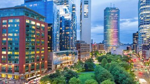 A cityscape with modern high-rise buildings, a central green space, and a busy street with vehicles. - InterContinental Boston by IHG (Boston)