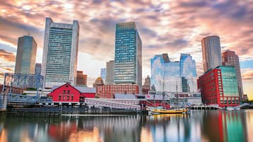 A waterfront cityscape with modern skyscrapers and a historic red building.