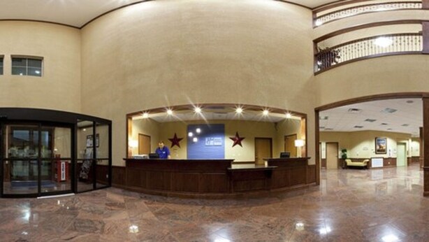 A hotel reception area with a curved reception desk, a glass entrance, and a balcony with railings. - Holiday Inn Express Salado-Belton by IHG (Salado)