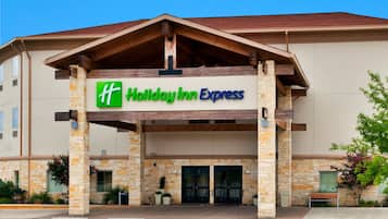 Welcome to the Holiday Inn Express, featuring a modern architectural design with a covered entrance and lush greenery.