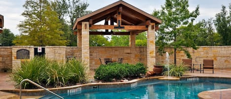 Una piscina al aire libre, tumbonas