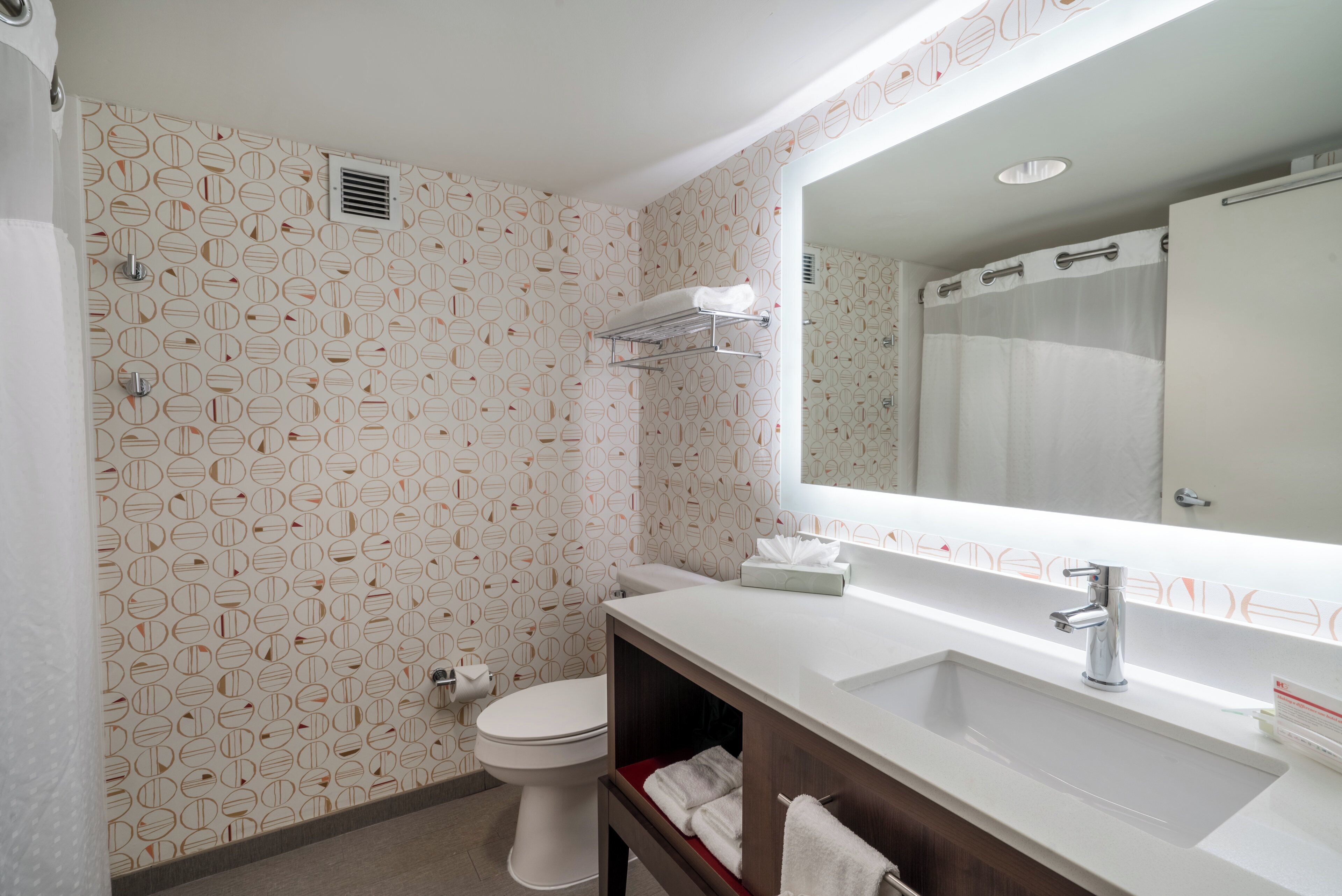 Un baño con inodoro, lavabo y espejo.