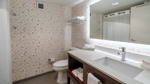 A bathroom with a toilet, sink, and mirror. - Holiday Inn Atlanta/Roswell by IHG (Roswell)