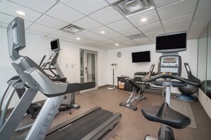 A gym with treadmills, elliptical machines, and weight benches.