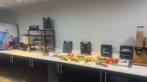 A breakfast buffet area with various food options and a Coca-Cola advertisement. - Holiday Inn Atlanta/Roswell by IHG (Roswell)