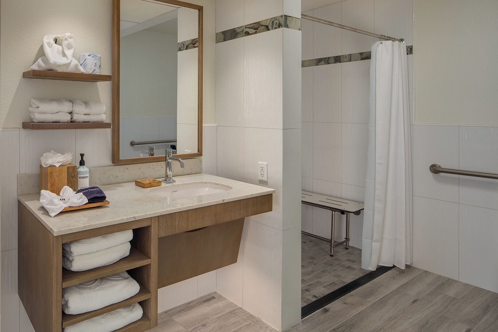 A modern bathroom with a sink, mirror, and shower.