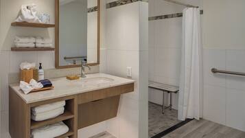 A modern bathroom with a sink, mirror, and shower.