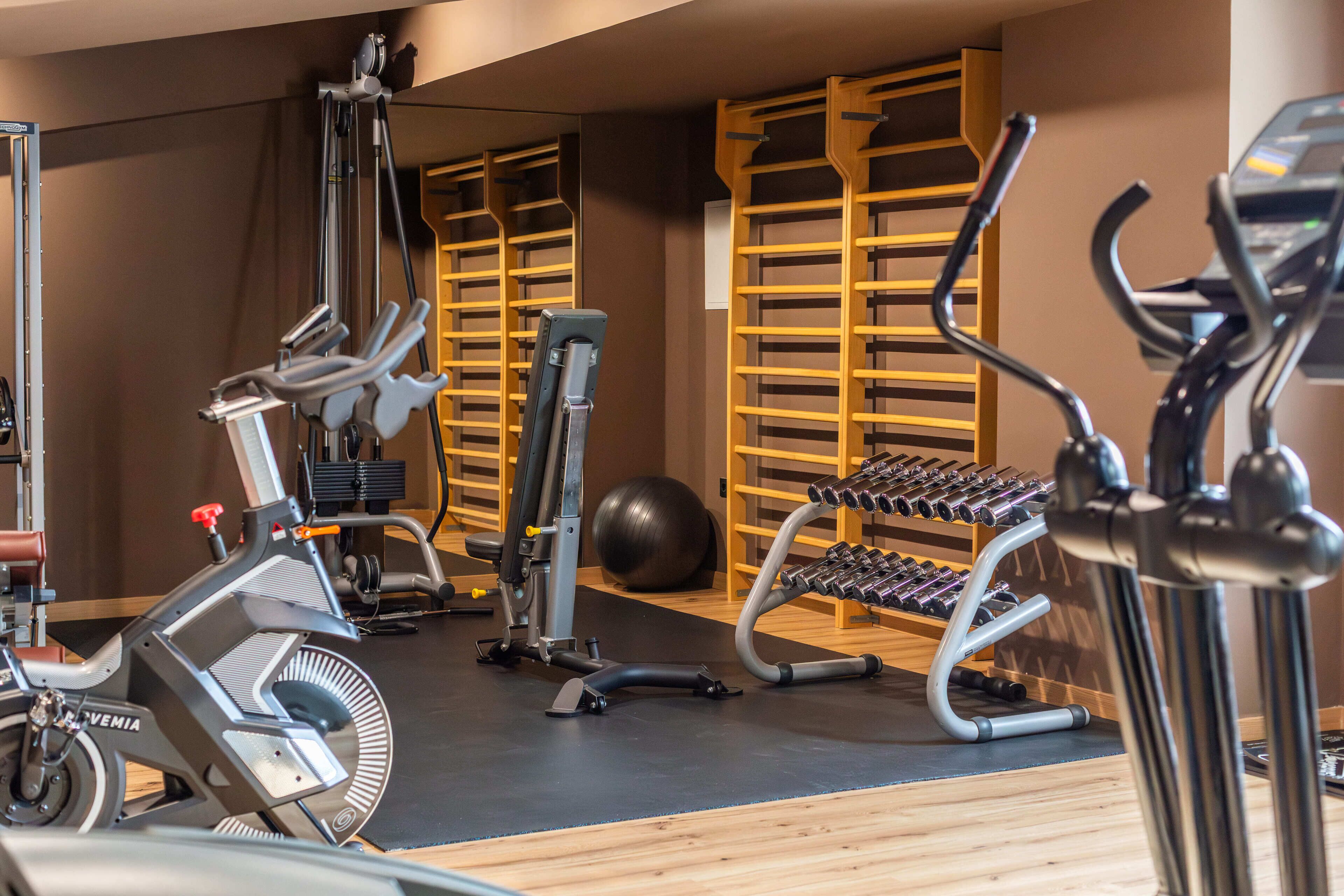 Un gimnasio con equipo de ejercicio, incluyendo una bicicleta estática, elíptica y máquinas de pesas.