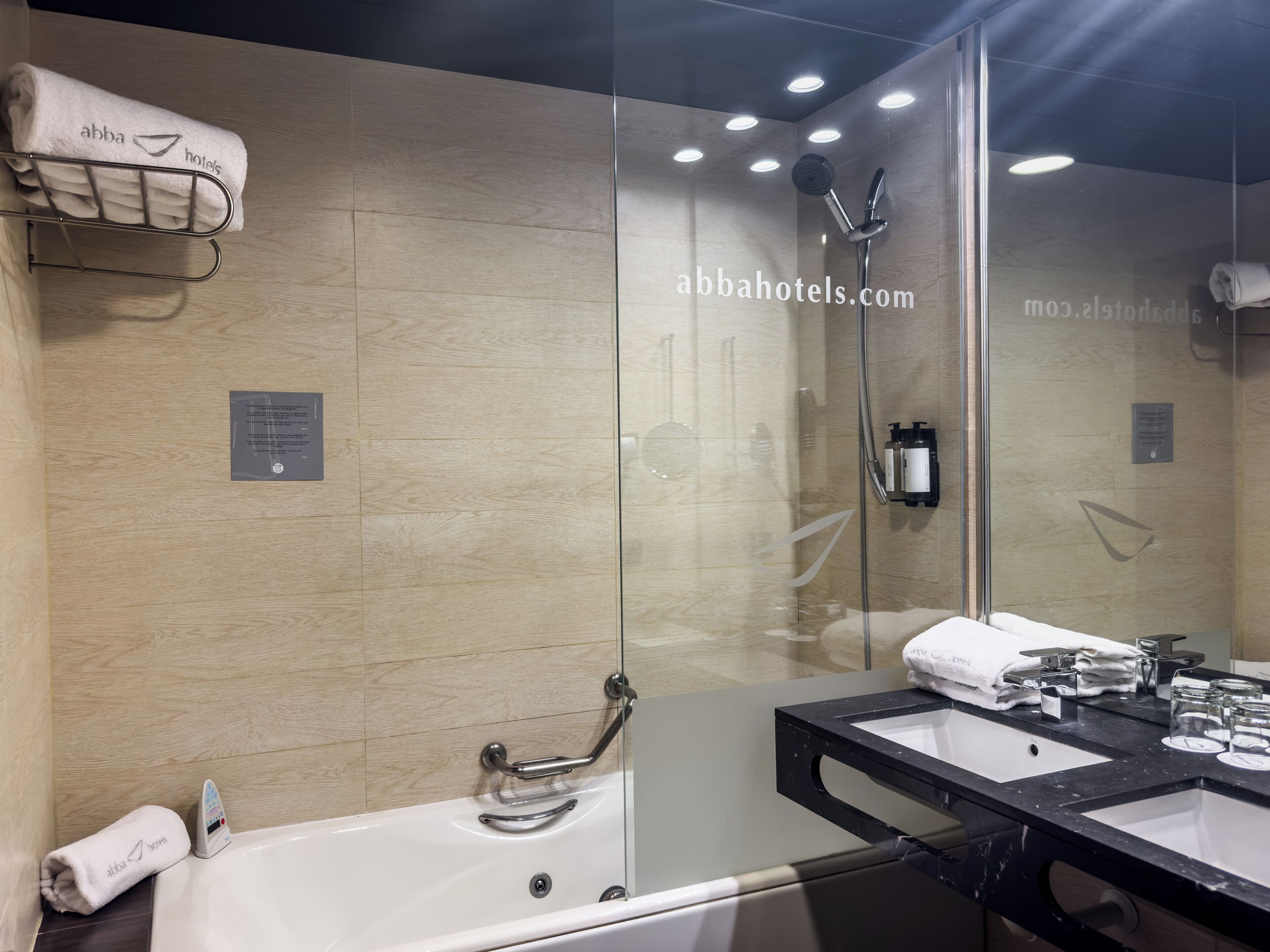 Un baño moderno con ducha de vidrio, bañera y tocador con espejo.
