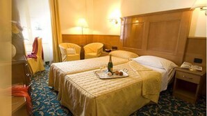 A hotel room with two beds, a nightstand, a lamp, and a chair. - Cinque Giornate (Milan)