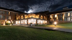 Un hotel con un patio central, numerosas ventanas y una entrada bien iluminada.