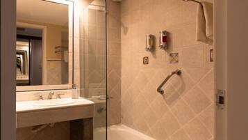 A bathroom with a glass-enclosed shower, a bathtub, a sink, and a mirror.