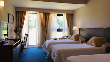 A hotel room with two beds, a desk with a computer, and a chair.