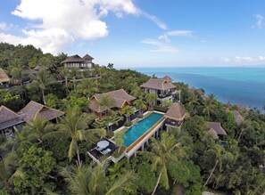 A resort with multiple bungalow-style buildings, a central swimming pool, and lush tropical vegetation. - Four Seasons Resort Koh Samui (Koh Samui)