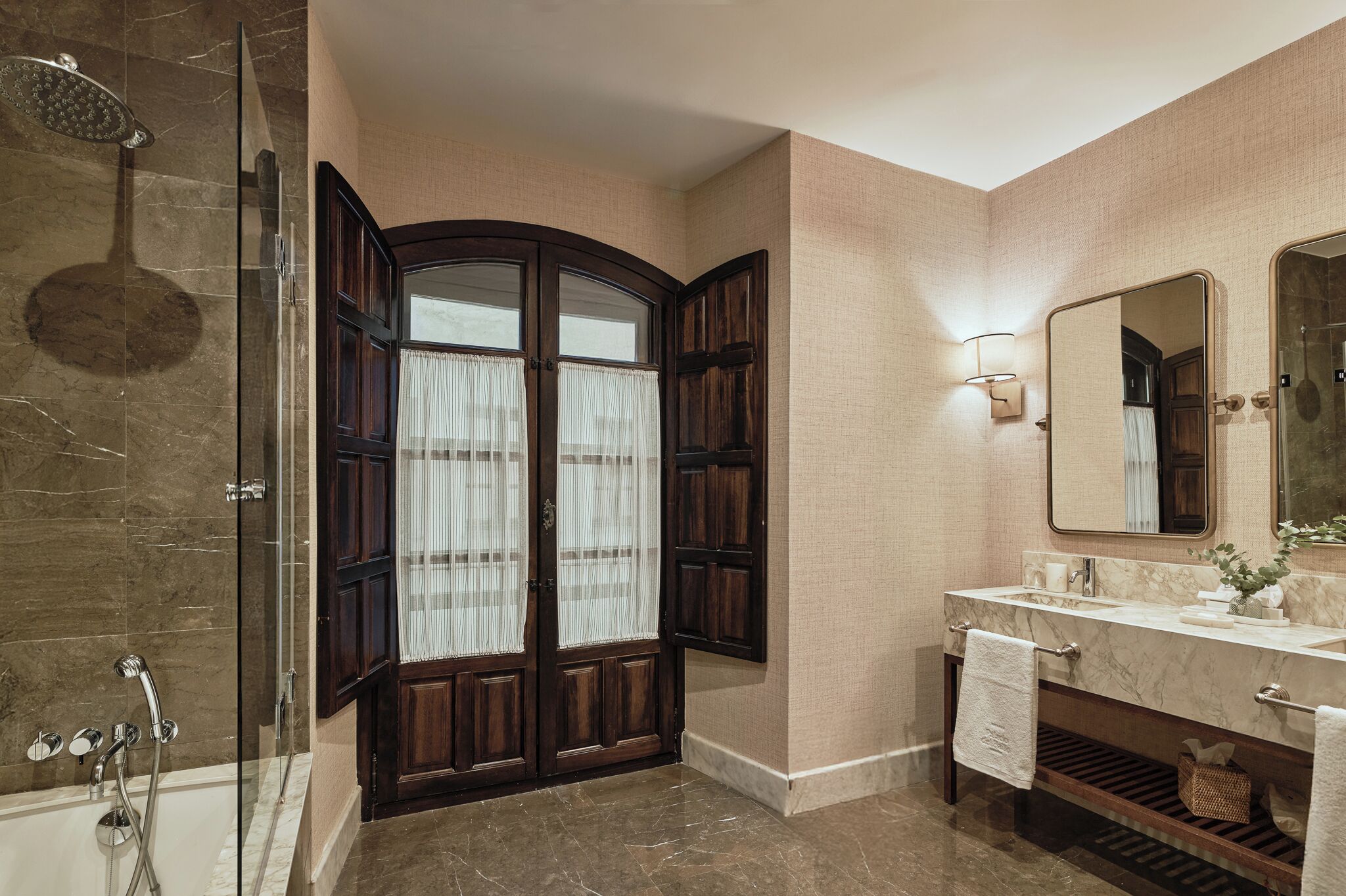 Une salle de bain avec une douche à parois de verre, un meuble-lavabo avec un miroir et un porte-serviettes.