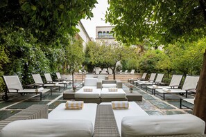 室外游泳池，開放時間為 10:00 至 20:00，提供泳池遮陽傘和日光浴躺椅