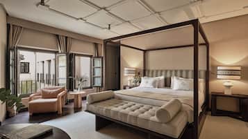 Un dormitorio amplio con cama con dosel, una zona de estar y vistas al exterior.