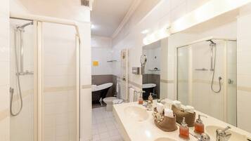A modern bathroom with a walk-in shower, a large vanity with multiple sinks, and a glass-enclosed shower area.