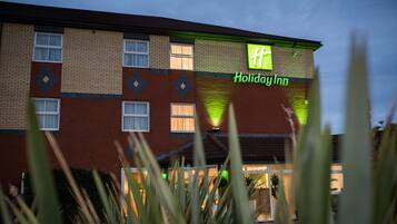 A Holiday Inn hotel with a brick facade and a green sign.