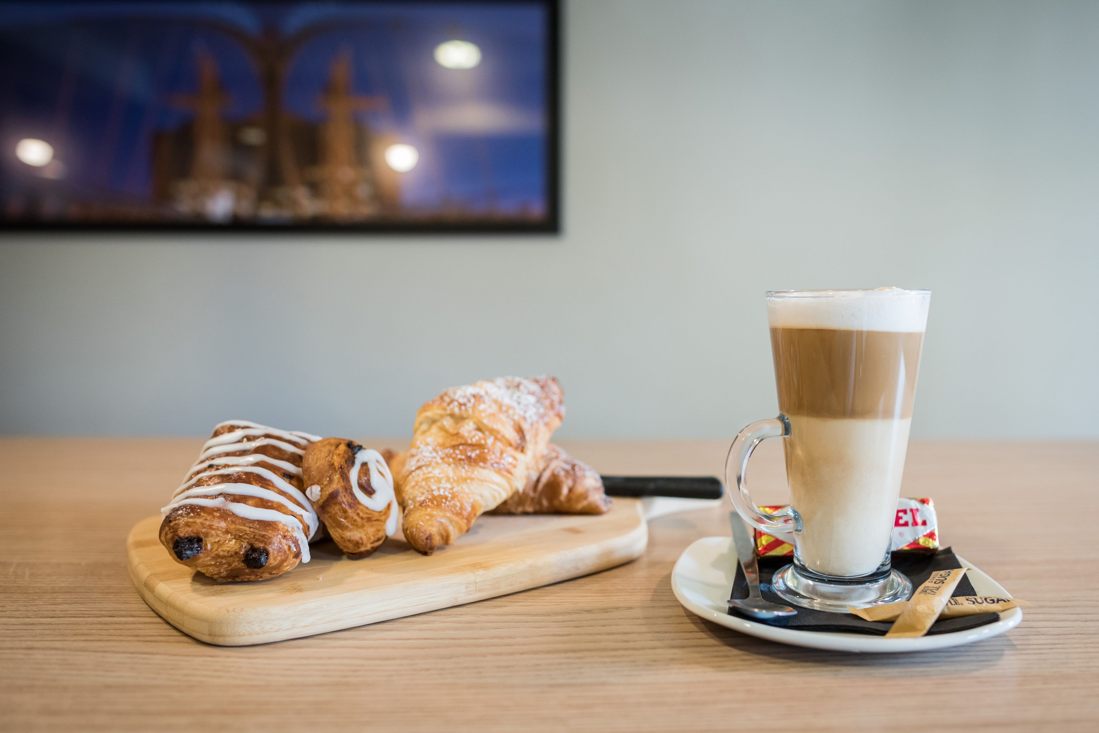 A wooden table with pastries and a glass of coffee.