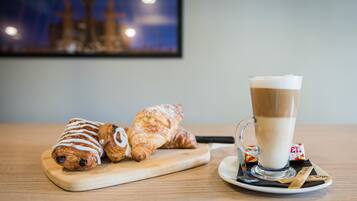 A wooden table with pastries and a glass of coffee.