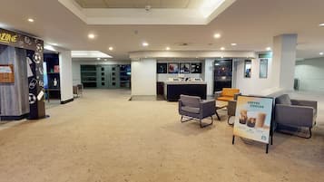 A spacious lobby with a reception desk, seating area, and a coffee cooler sign.