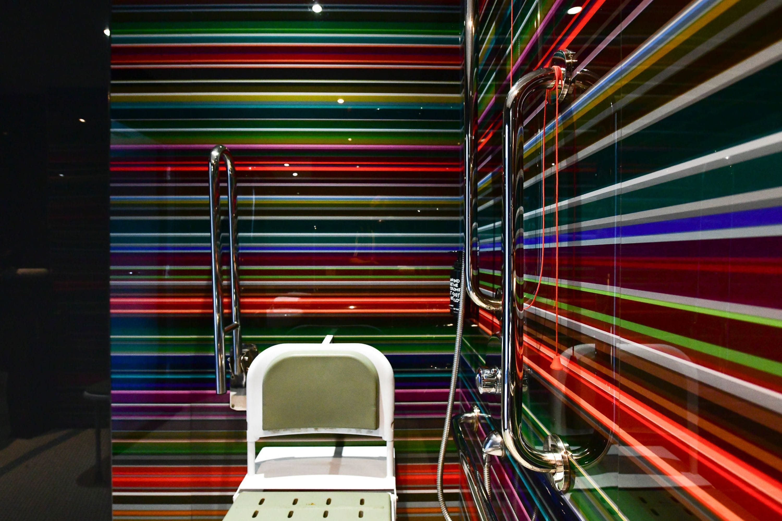 Ein modernes Badezimmer mit Glasabtrennung und einer weißen Badewanne.