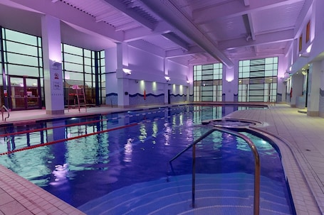 Una piscina techada, sillones reclinables de piscina