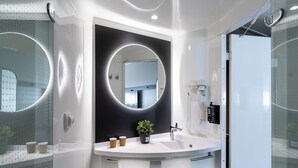 A modern bathroom with a large mirror, a round sink, and a potted plant. - ibis Barcelona Aeropuerto Viladecans (Viladecans)