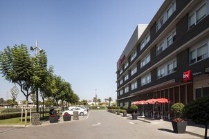 Um hotel com design moderno, com estacionamento, área de estar ao ar livre e céu claro.