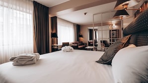 A hotel room with a large bed, a desk, a chair, and a mirror. - Suites del Bosque Hotel (Lima)