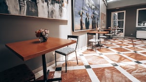 A modern interior with a checkered floor, wooden tables, and chairs, and large abstract paintings on the walls. - Suites del Bosque Hotel (Lima)