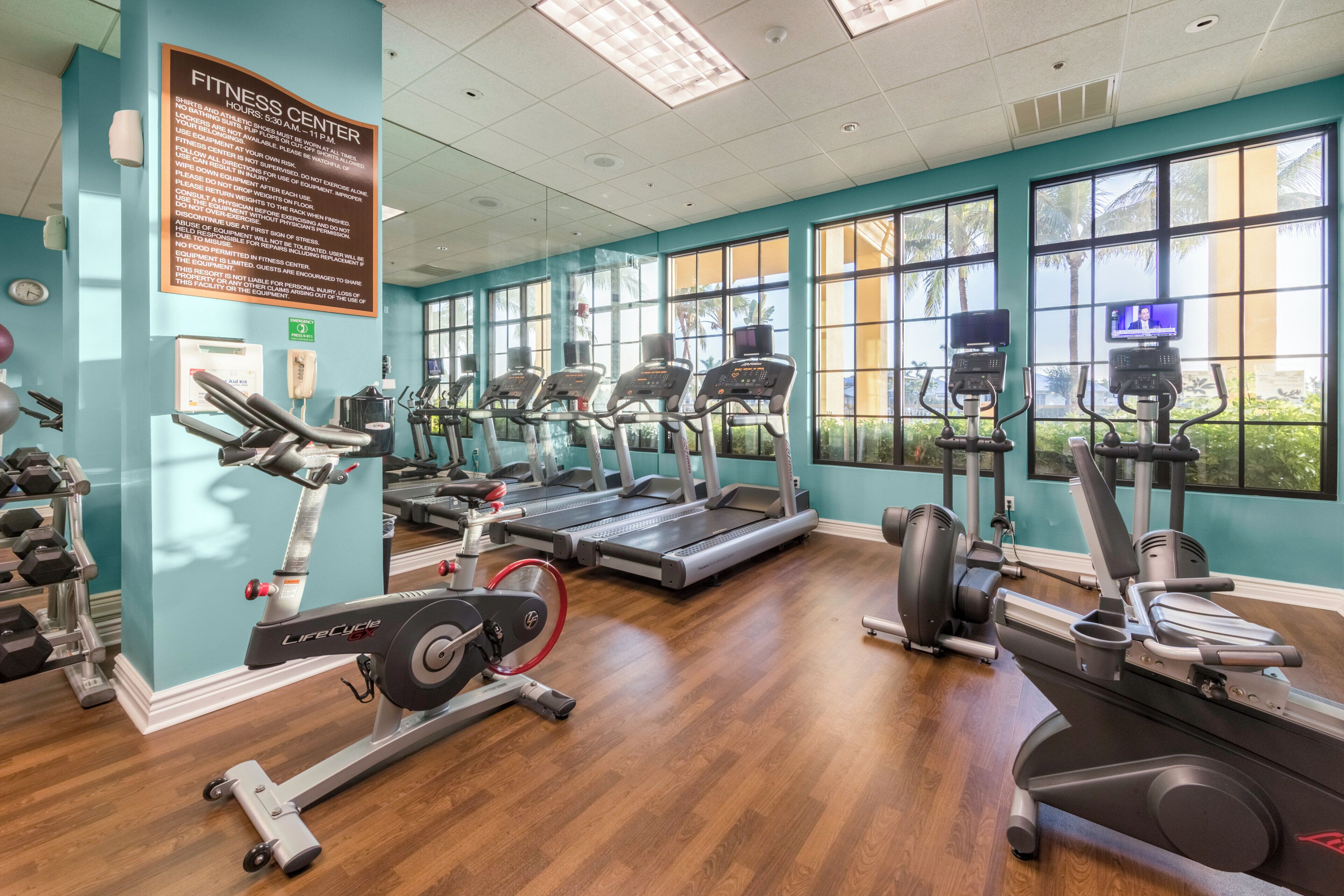 A fitness center with treadmills, elliptical machines, and weight equipment.