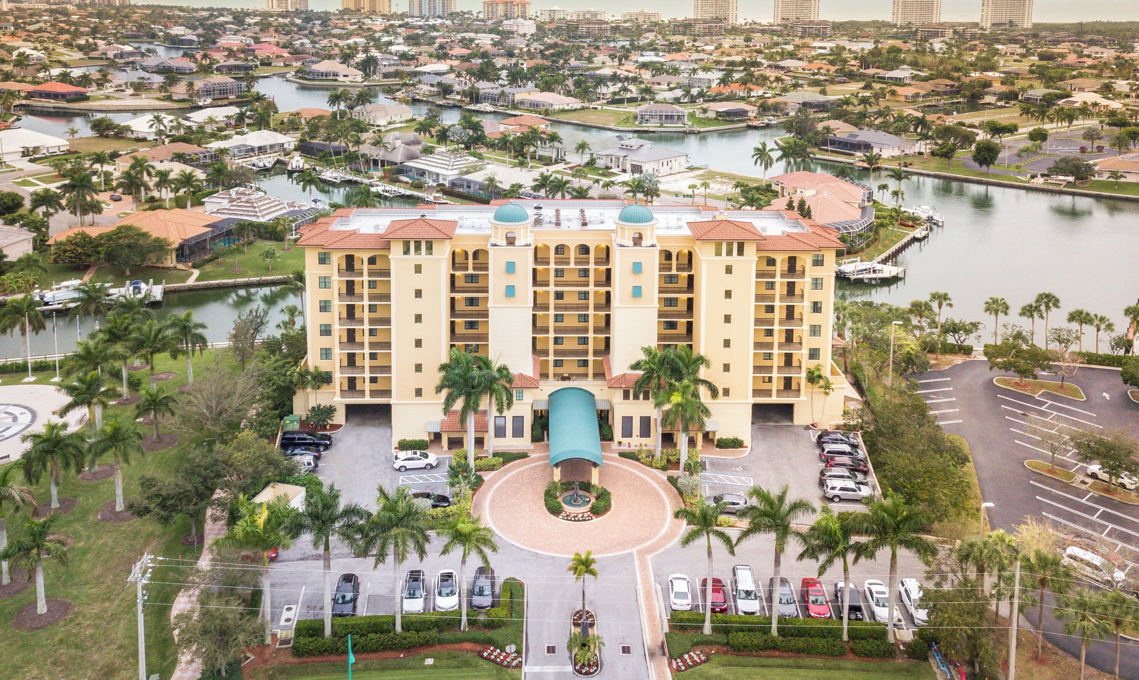 A hotel with a central courtyard, multiple floors, and a waterfront view.