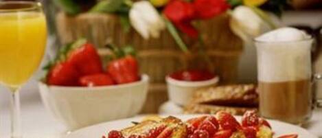 A breakfast setting with a plate of food, a glass of orange juice, and a cup of coffee.