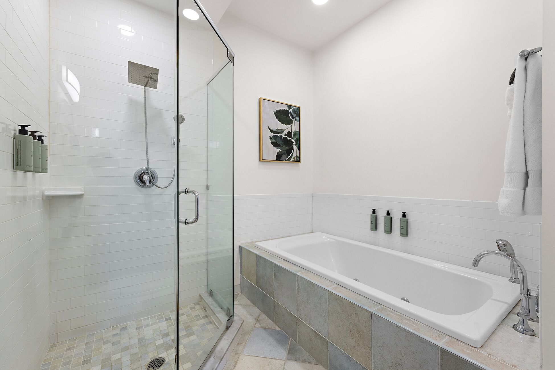 A modern bathroom with a glass-enclosed shower, a freestanding bathtub, and a wall-mounted sink.