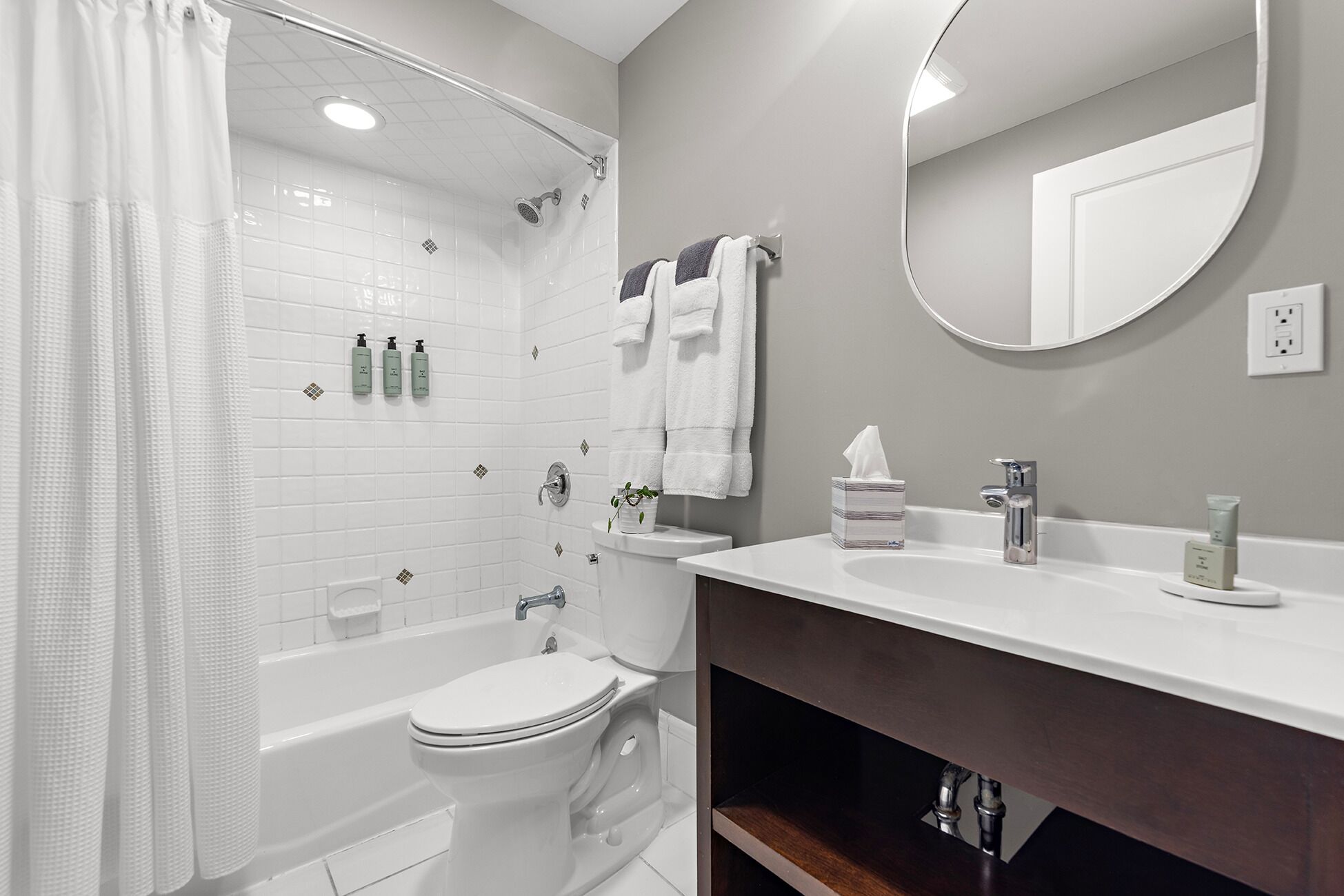 A modern bathroom with a bathtub, toilet, and sink.