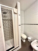 Un bagno con doccia, WC e lavandino.