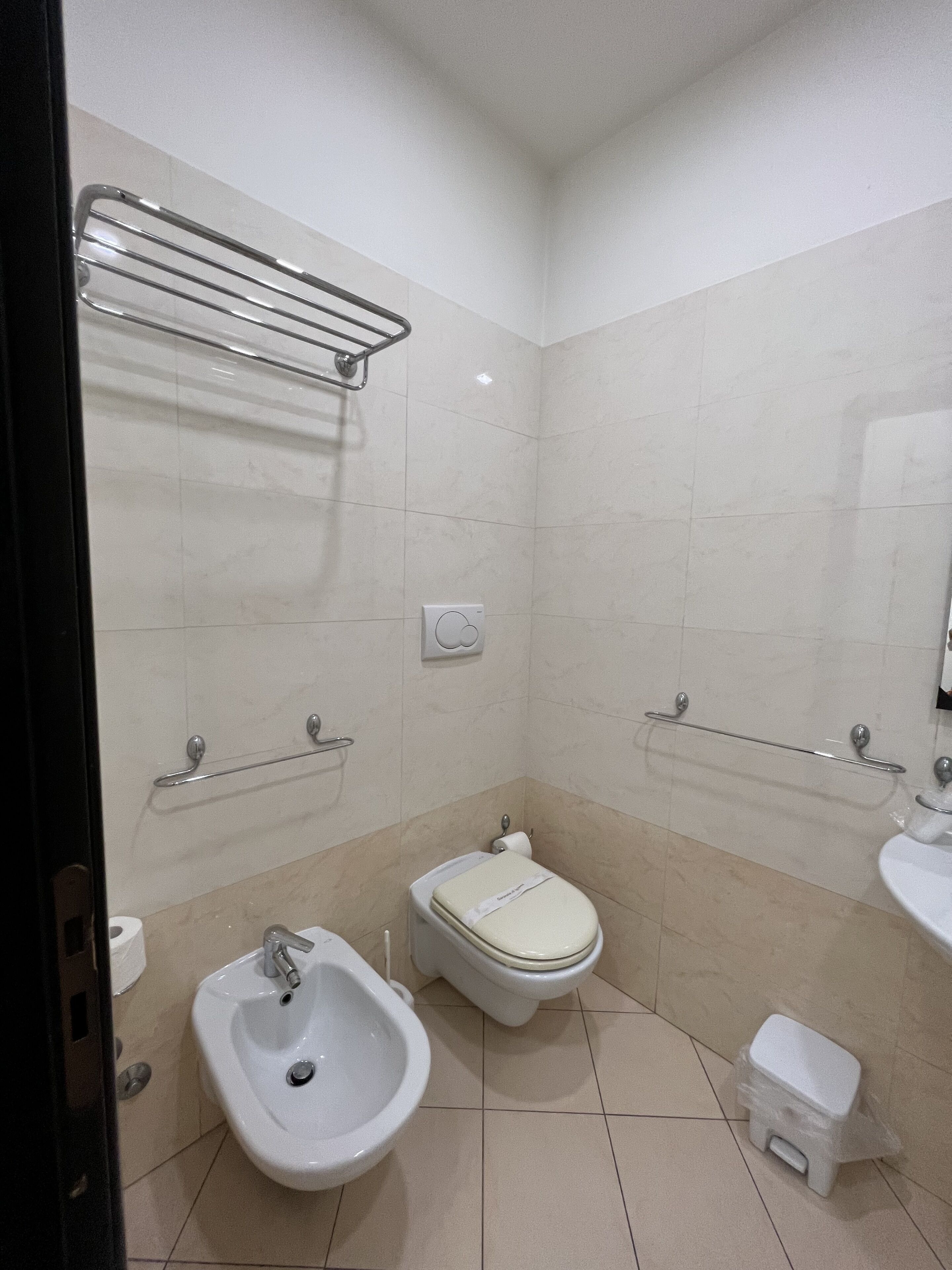 A modern bathroom with a bidet, toilet, and sink.