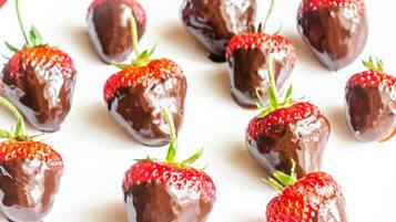 A white plate with chocolate-covered strawberries arranged on it.
