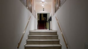A staircase with a handrail on both sides, leading to a landing with a door at the top.