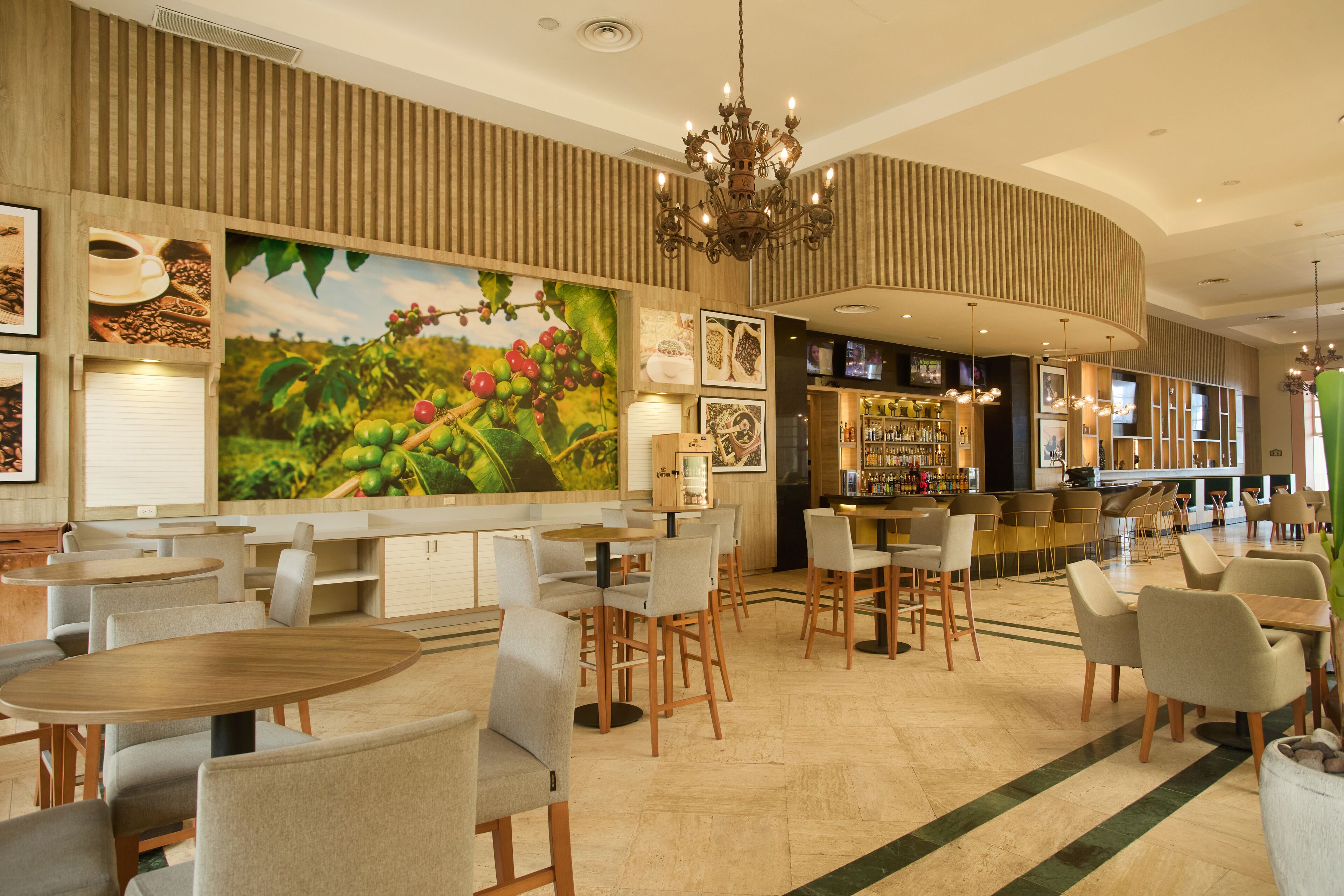 A spacious restaurant with high ceilings, a central bar area, and a large mural of a fruit tree.
