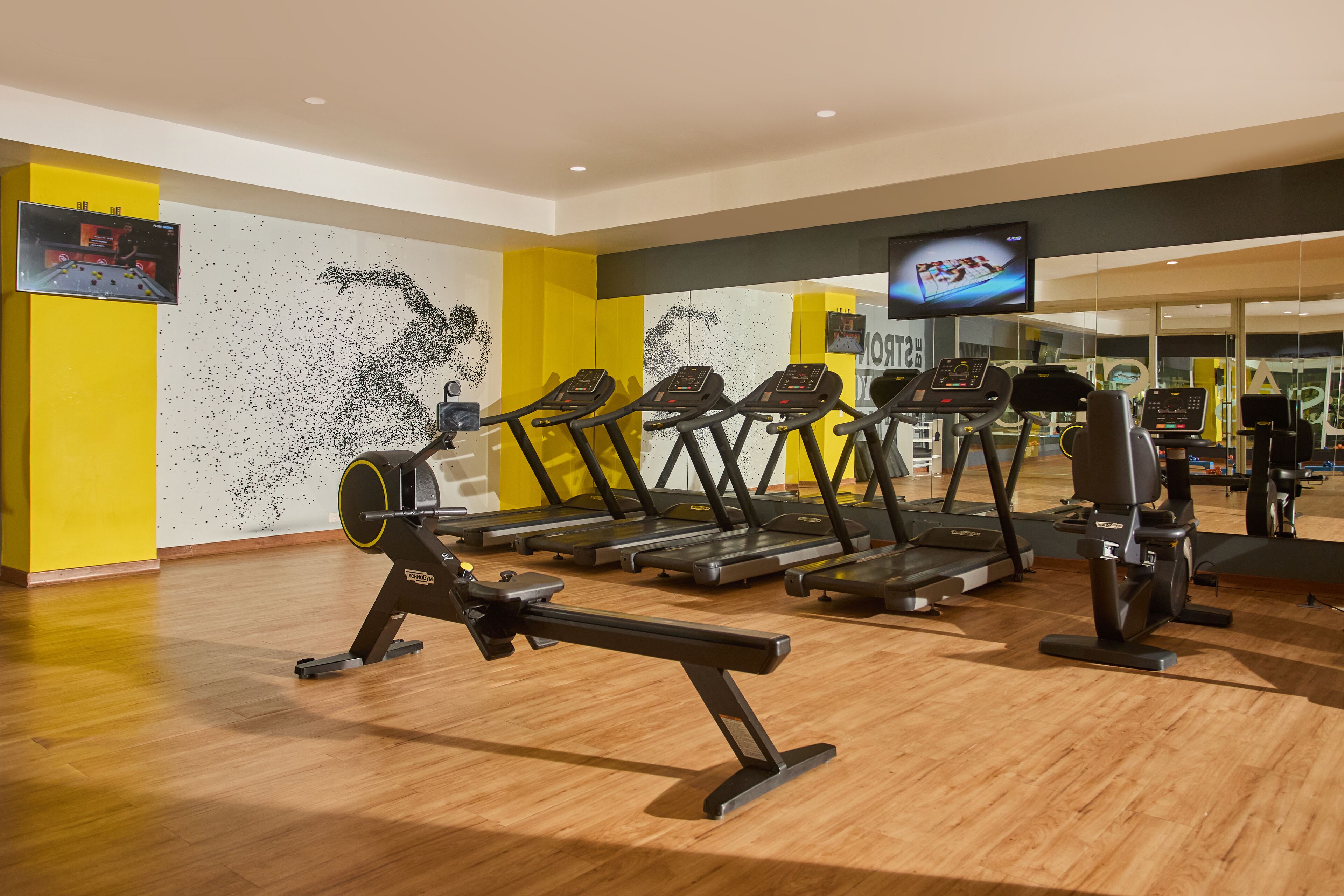 A gym with treadmills, stationary bikes, and a rowing machine.