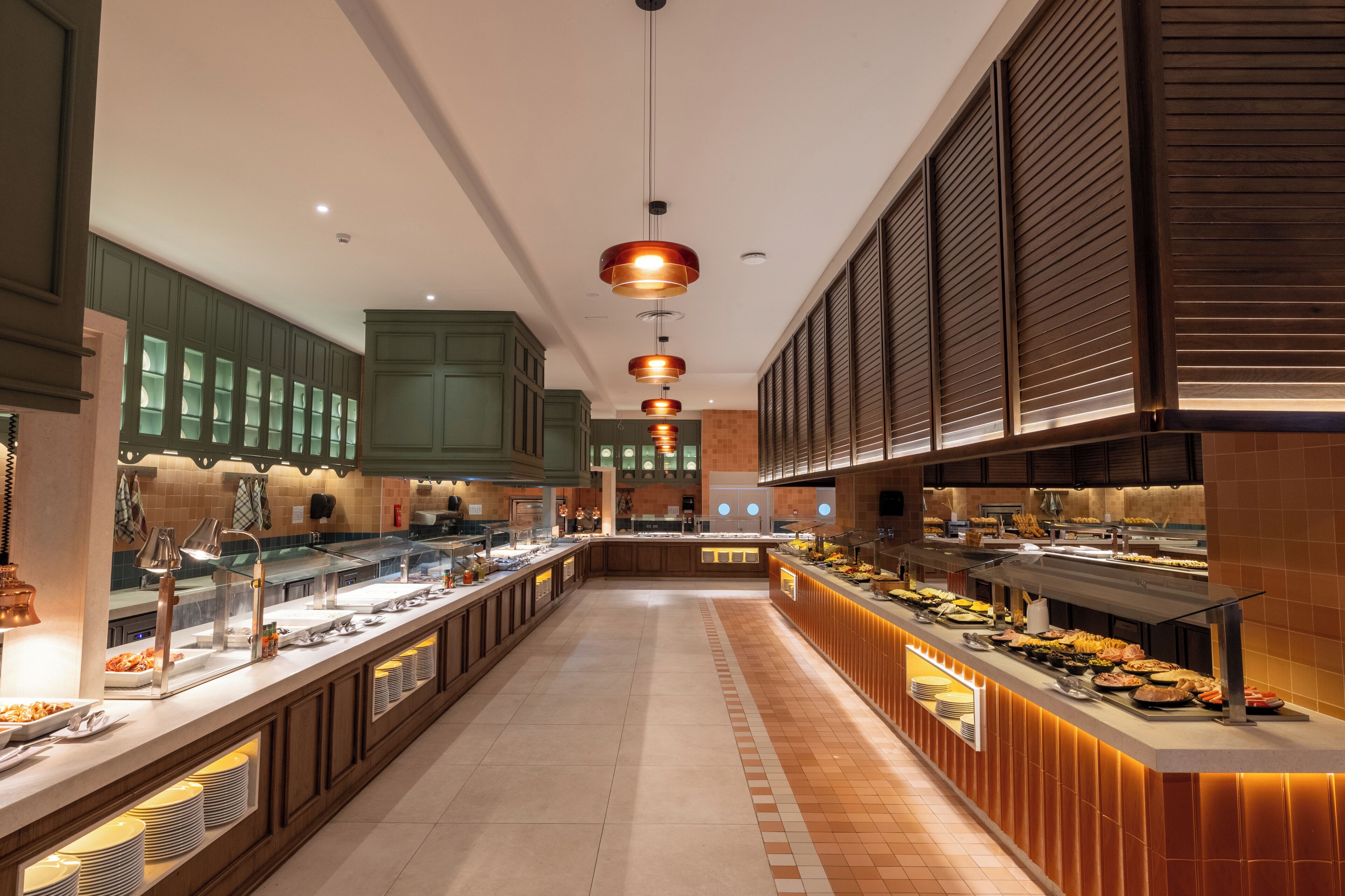 Una barra de buffet con varias estaciones de comida y una larga mesa.