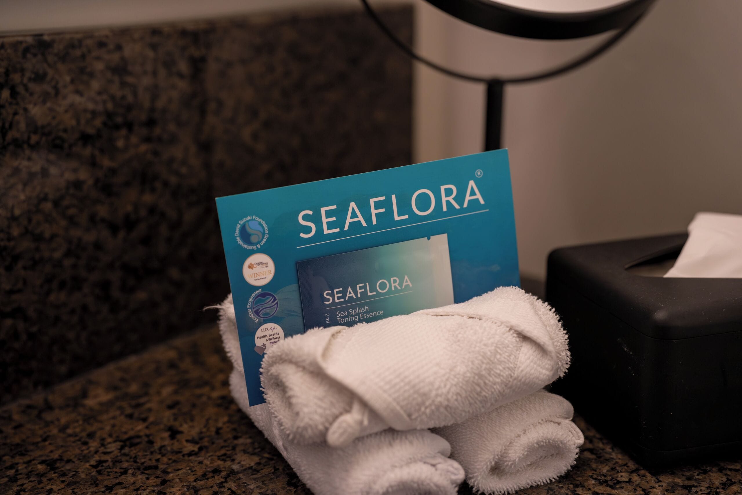 A Seaflora product box on a countertop with a rolled-up towel and a tissue box.